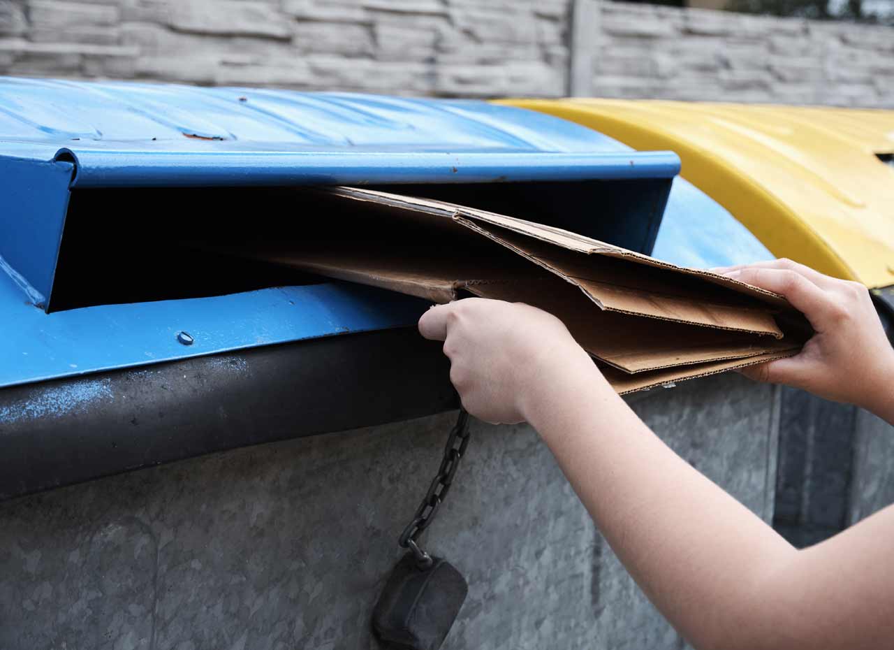placing cardboard in recycling container